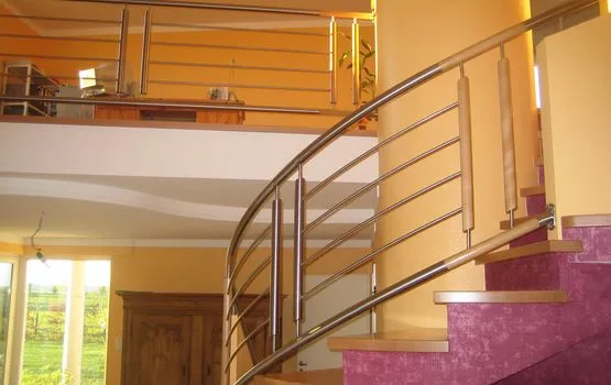 Geschwungene Galerietreppe mit Holzhandlauf